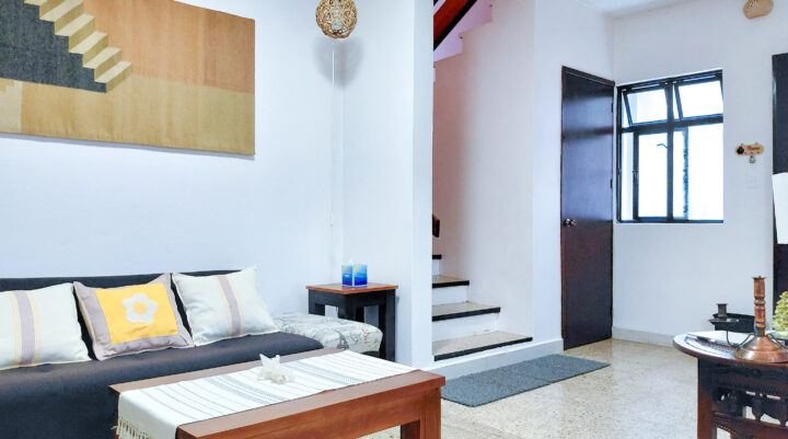 Living room entry with artisanal textile hung above.